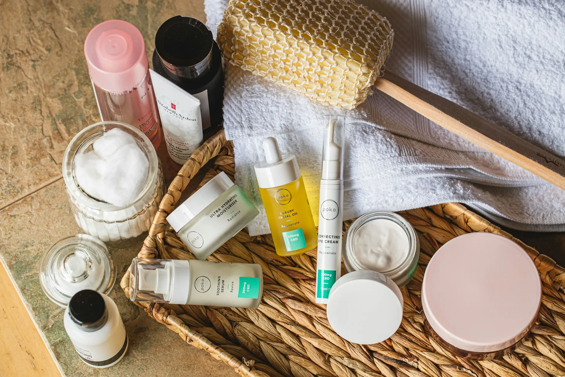 Aneka produk skincare berupa krim dalam jar, serum, dan botol pump di atas keranjang anyaman