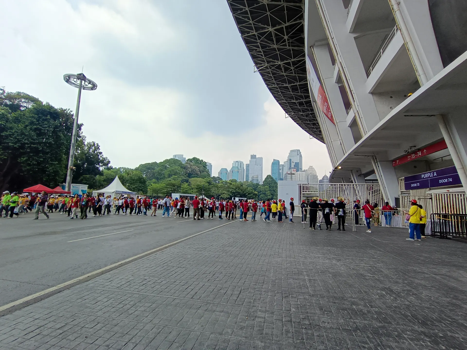 Pengunjung berbaris menuju pintu 73 Stadion Utama Gelora Bung Karno yang dijaga petugas di balik pagar pembatas