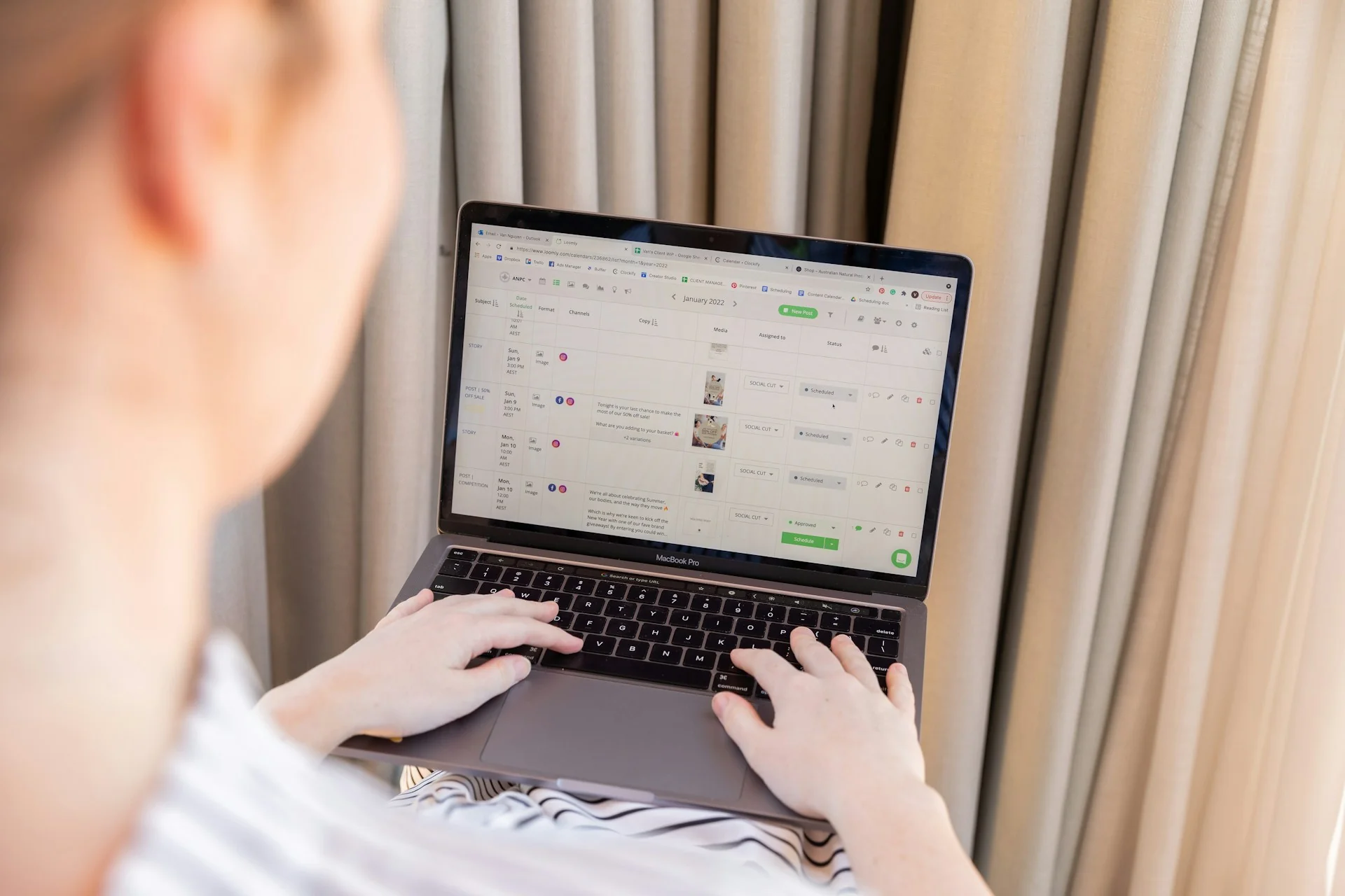 Seseorang mengetik di laptop yang menampilkan aplikasi pengelola jadwal kerja