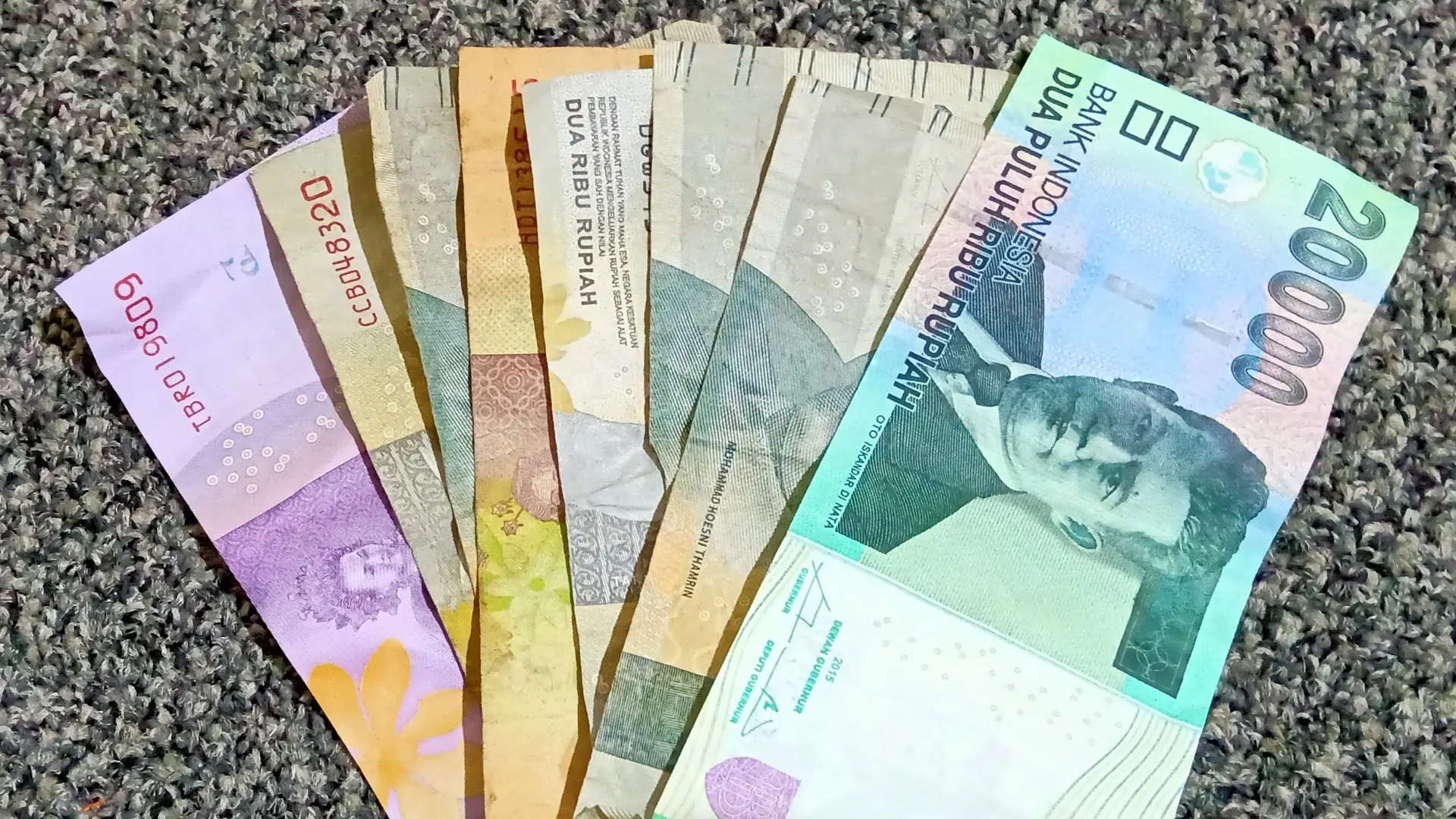 Uang kertas rupiah pecahan 2 ribu hingga 20 ribu disusun berjajar di atas karpet