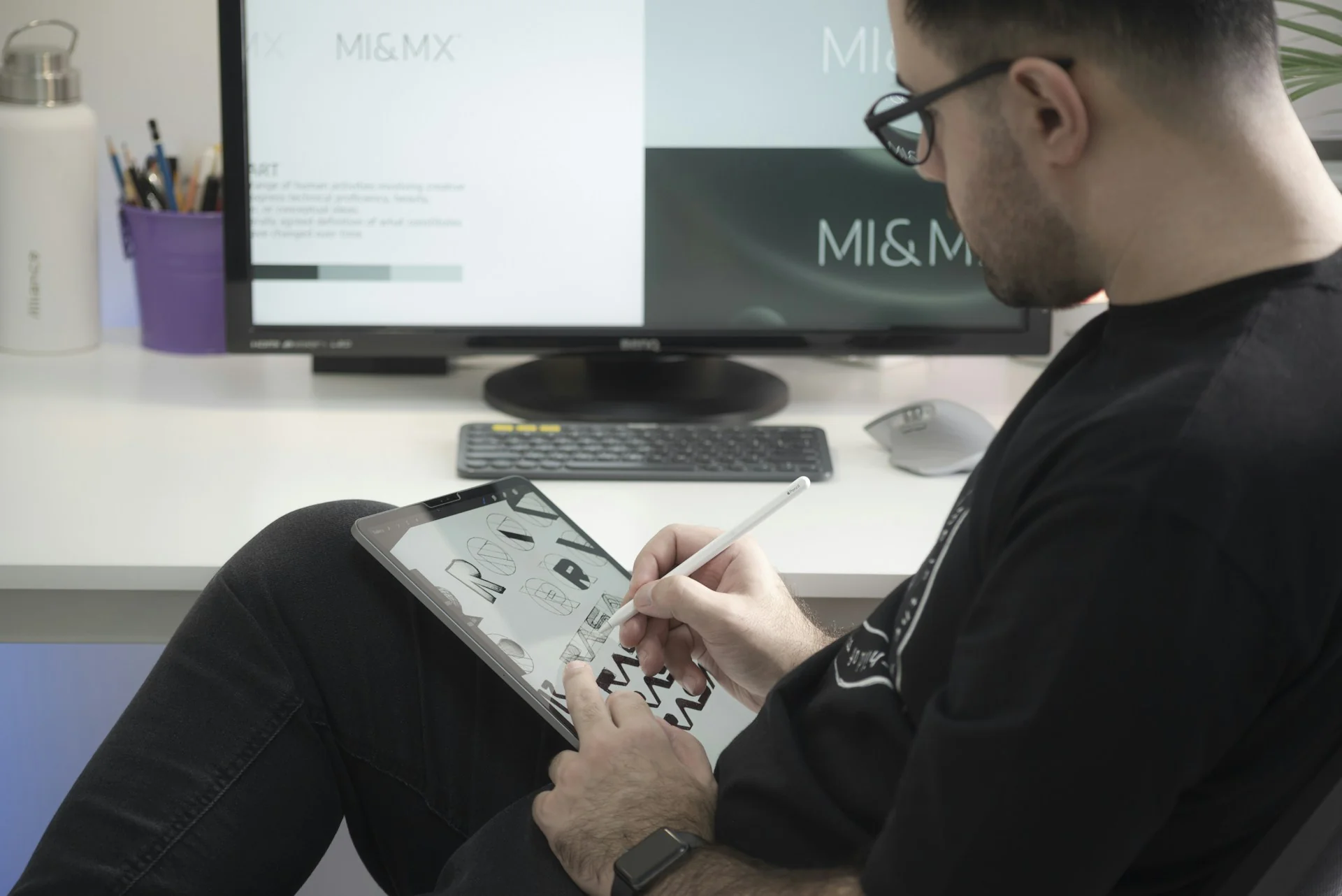 Desainer grafis menggambar sketsa di tablet gambar di depan monitor