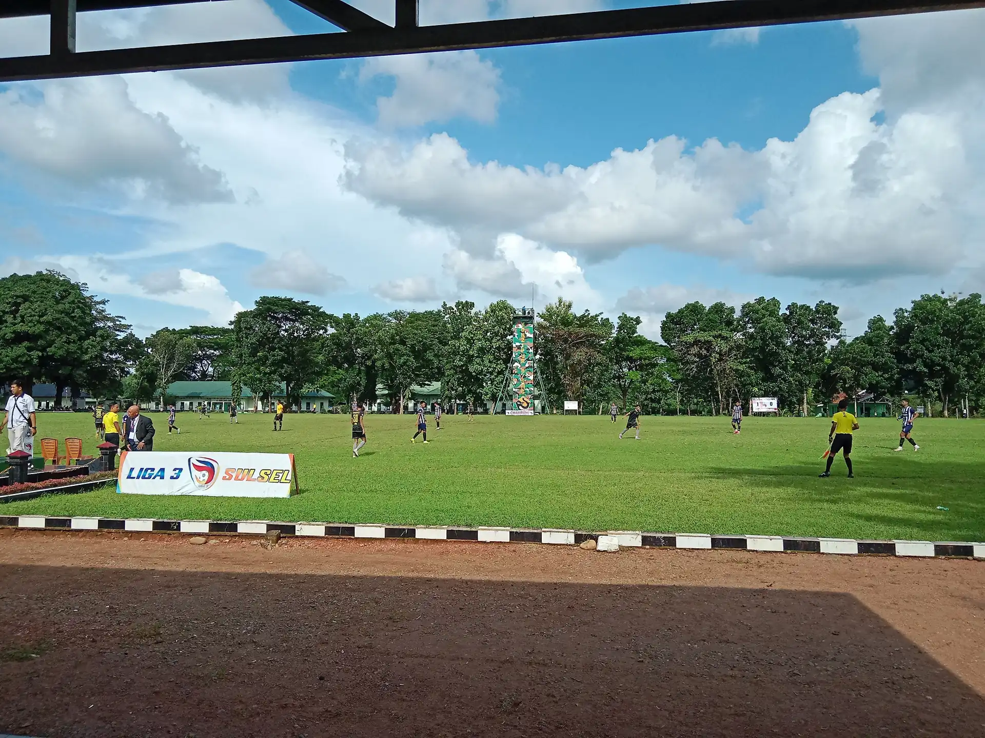 Pertandingan final Liga 3 Sulawesi Selatan antara Mangiwang FC dan Persim Maros dengan papan Liga 3 di pinggir lapangan