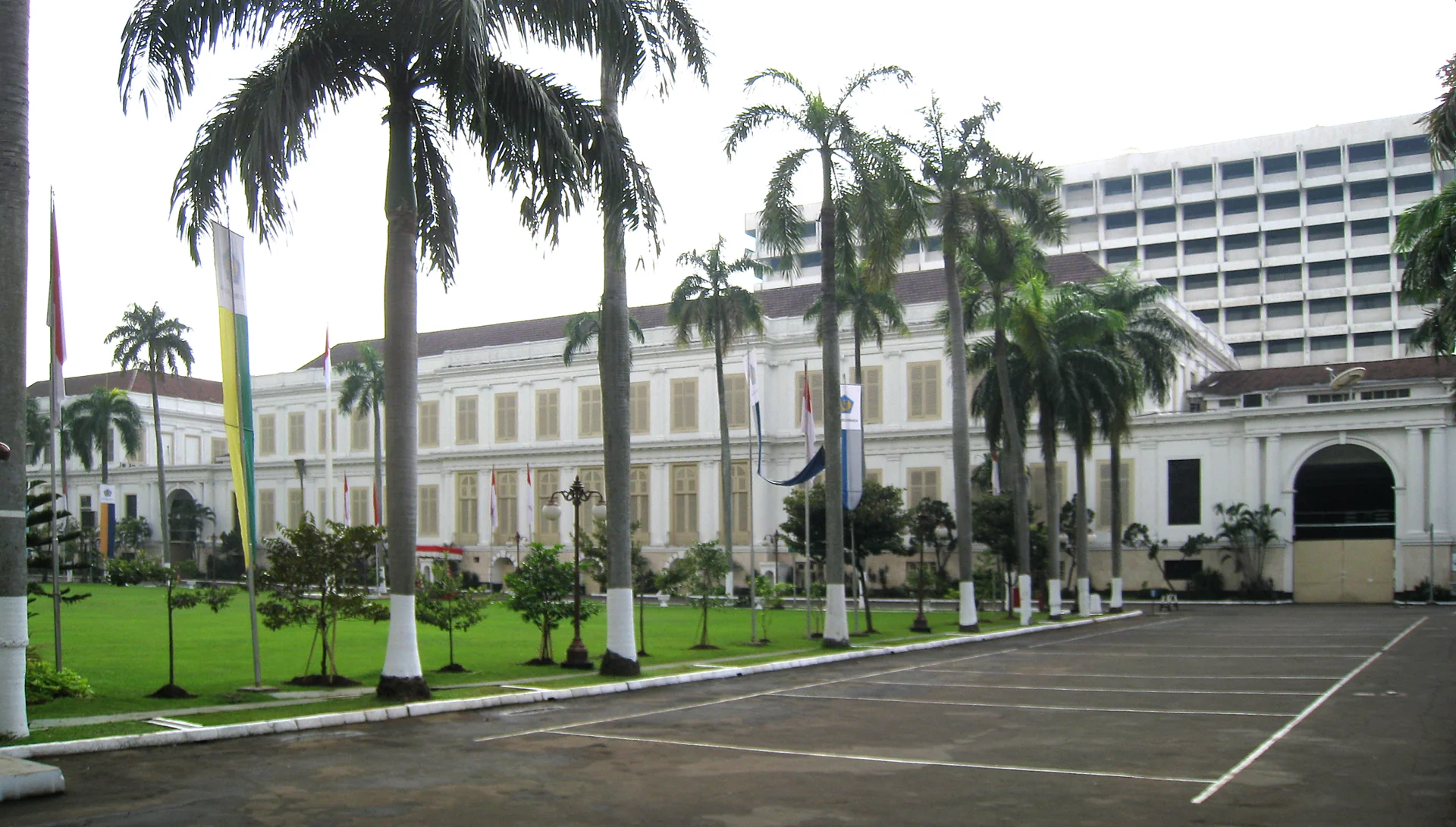 Gedung bergaya kolonial berwarna putih dengan deretan pohon palem dan halaman parkir di kompleks Kementerian Keuangan, Lapangan Banteng, Jakarta