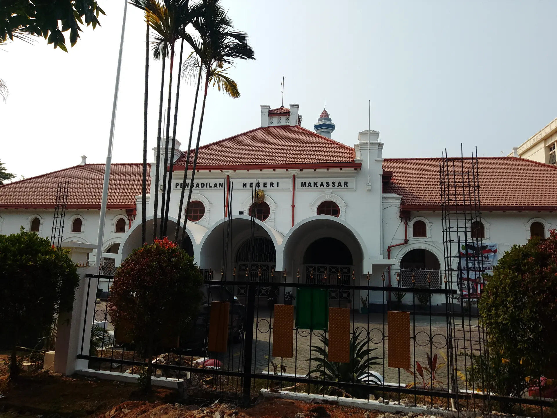 Tampak depan gedung Pengadilan Negeri Makassar bergaya kolonial dengan atap merah dan pagar besi