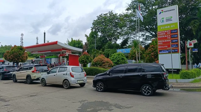 Antrean mobil di SPBU Pertamina 31.168.01 dengan tiang papan harga Pertamax Turbo, Pertamax, Dexlite, dan Pertalite