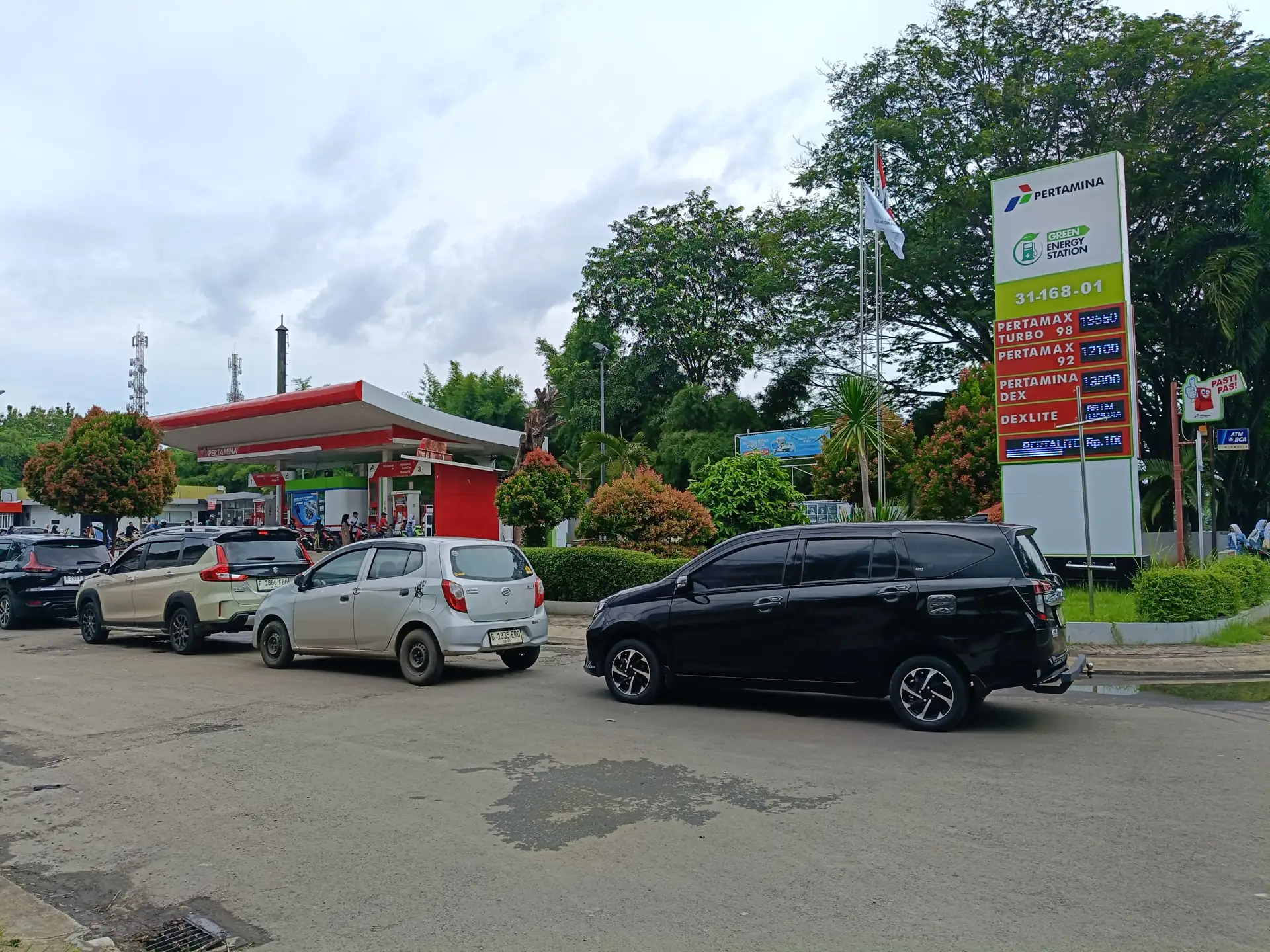 Antrean mobil di SPBU Pertamina 31.168.01 dengan tiang papan harga Pertamax Turbo, Pertamax, Dexlite, dan Pertalite