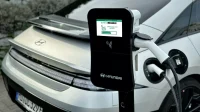 Hyundai Ioniq 6 putih sedang mengisi daya dengan kabel tercolok ke tiang charger AC