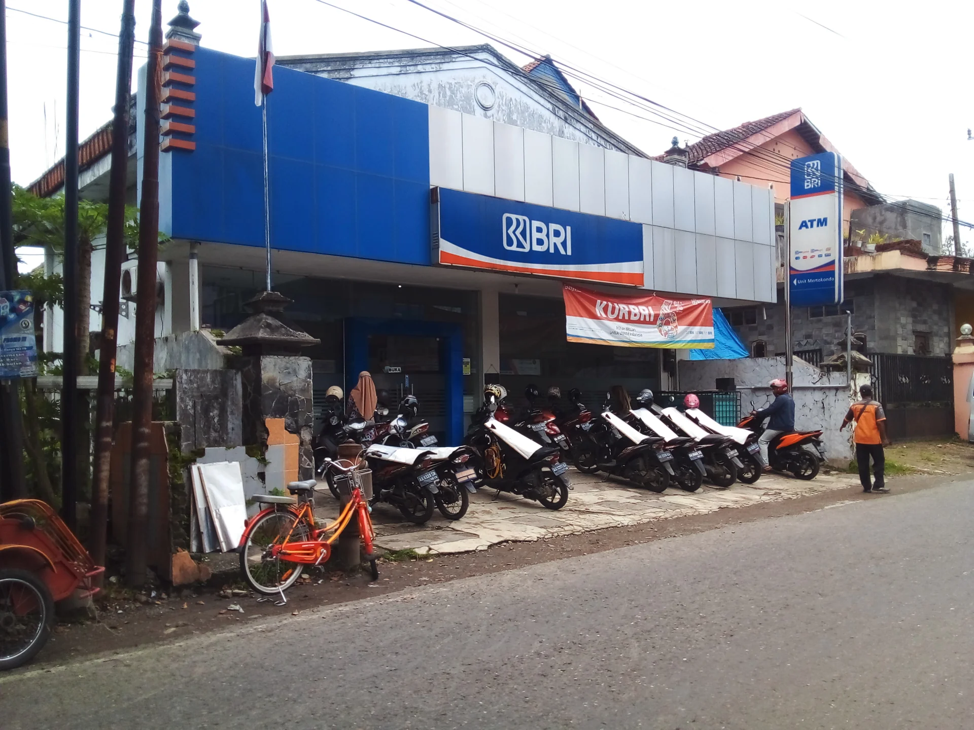 Kantor BRI Unit Mertokondo di Kebumen dengan papan logo BRI, tanda ATM, dan deretan sepeda motor nasabah di halaman depan