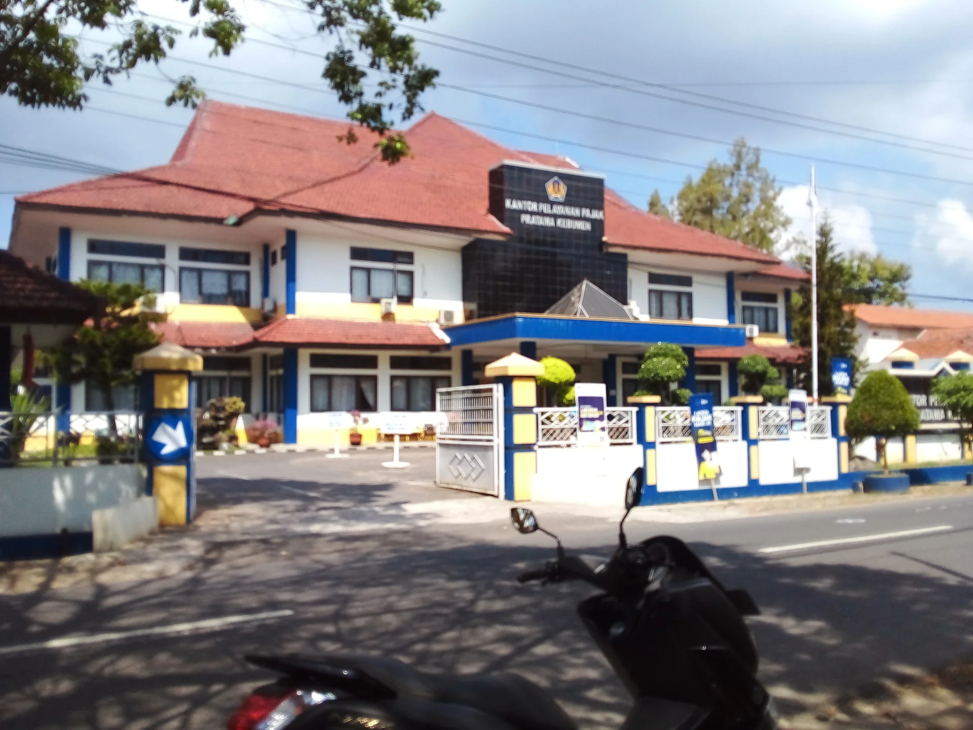 Gedung Kantor Pelayanan Pajak Pratama Kebumen beratap merah dengan papan nama di bagian depan