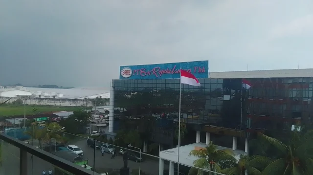 Gedung kantor pusat PT Sri Rejeki Isman Tbk (Sritex) berpapan nama biru dengan bendera Merah Putih dan atap pabrik di kawasan industri Sukoharjo