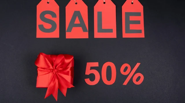 Label SALE merah dan angka diskon 50 persen di samping kotak kado