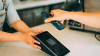Memindai kode QR di meja kasir Pembeli memegang ponsel untuk memindai kode QR di layar perangkat kasir di meja kedai