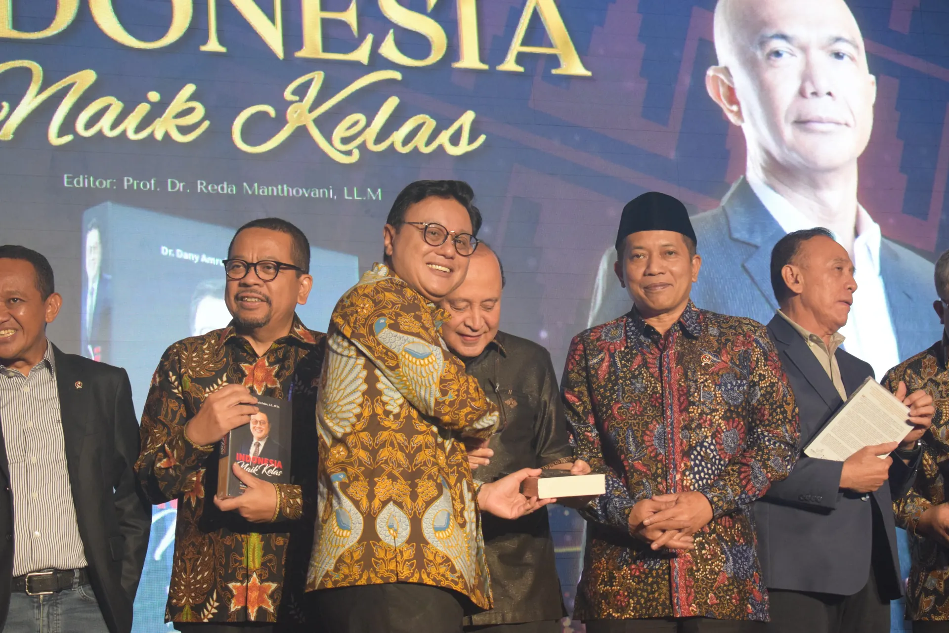 Ferry Juliantono berpeci hitam dan berbatik berdiri bersama sejumlah pejabat di panggung peluncuran buku Indonesia Naik Kelas