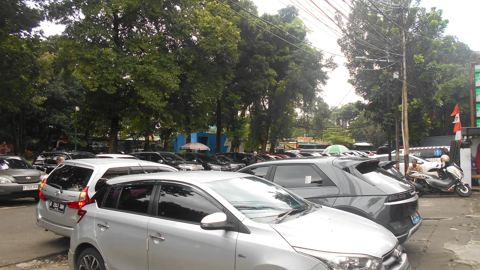 Deretan mobil berpelat B parkir di tepi jalan Kebayoran Baru Jakarta Selatan