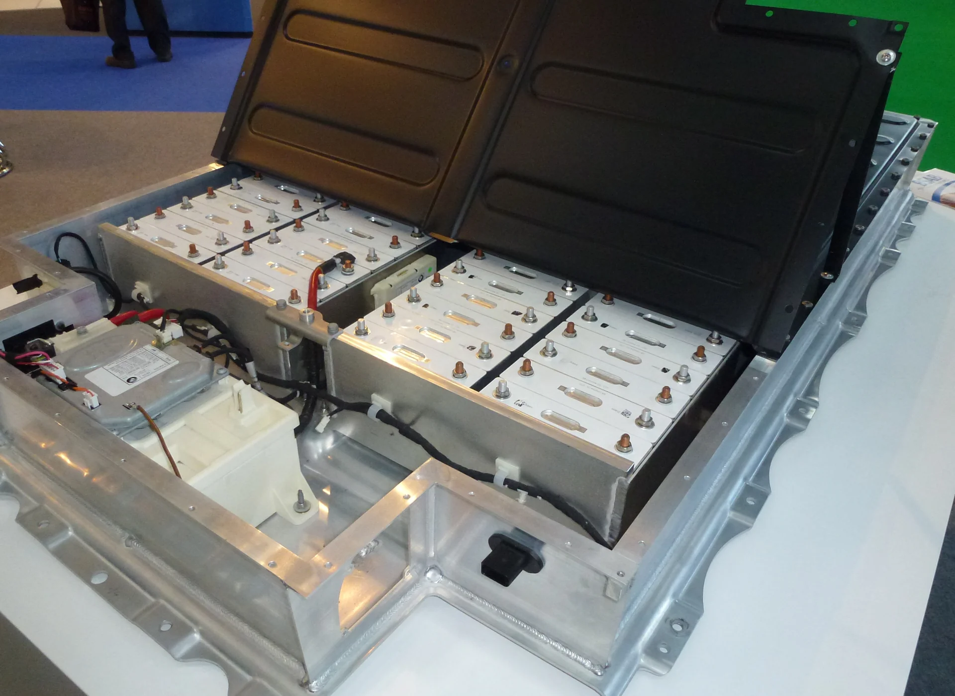 Paket baterai lithium-ion BMW i3 dengan tutup terbuka memperlihatkan deretan sel baterai prismatik