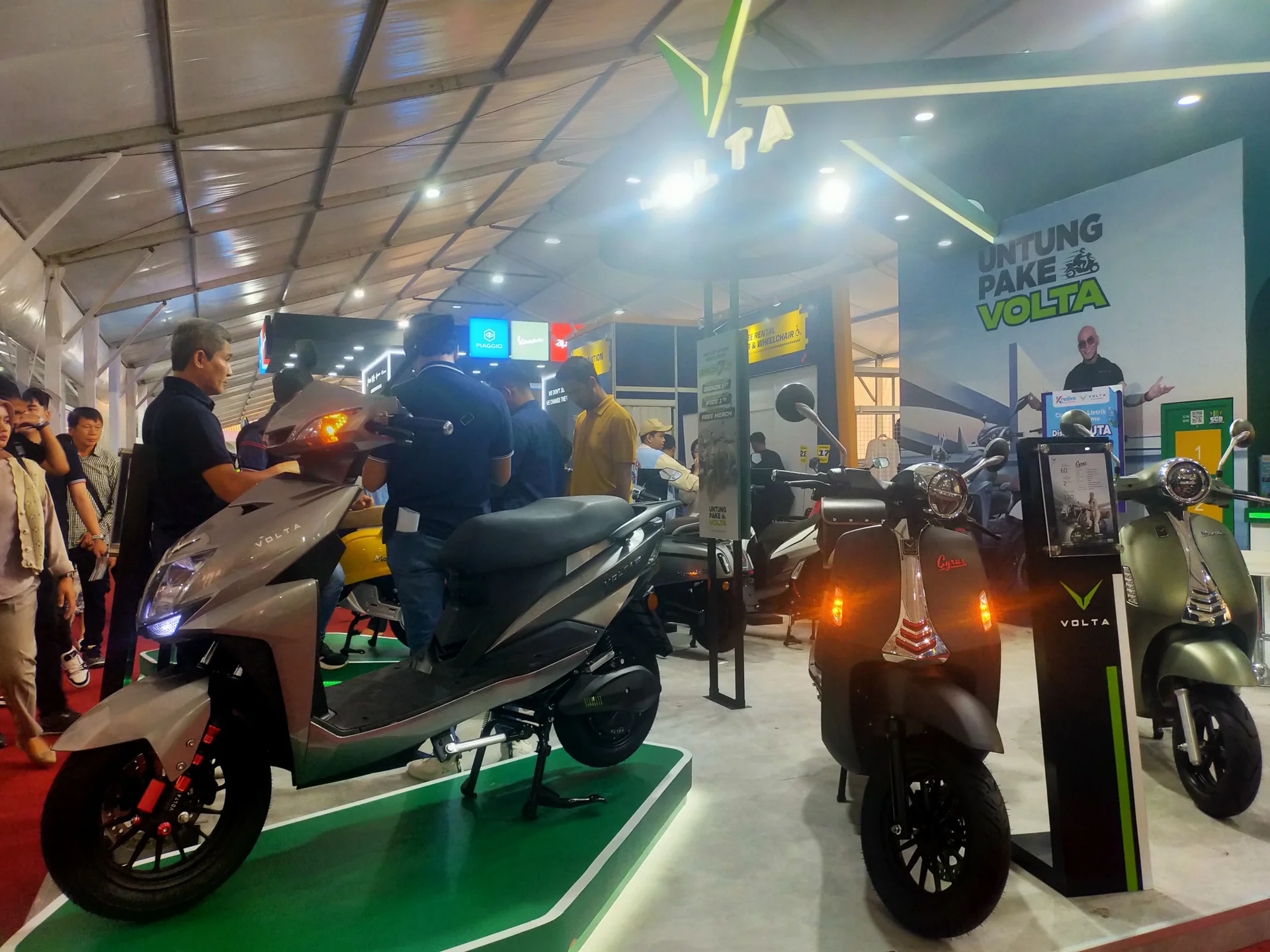 Deretan motor listrik Volta dipajang di stan pameran GIIAS 2024 dan dilihat pengunjung