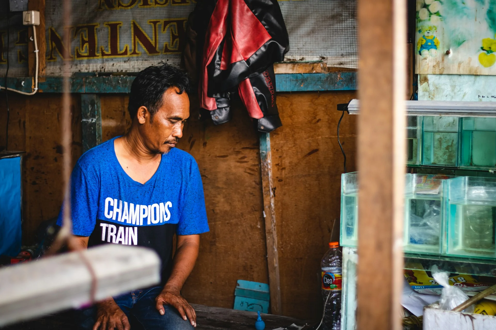 Pedagang ikan hias duduk di samping kios kecilnya