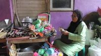Pedagang perabot rumah tangga di pasar tradisional menghitung uang, contoh wajib pajak PPh final UMKM