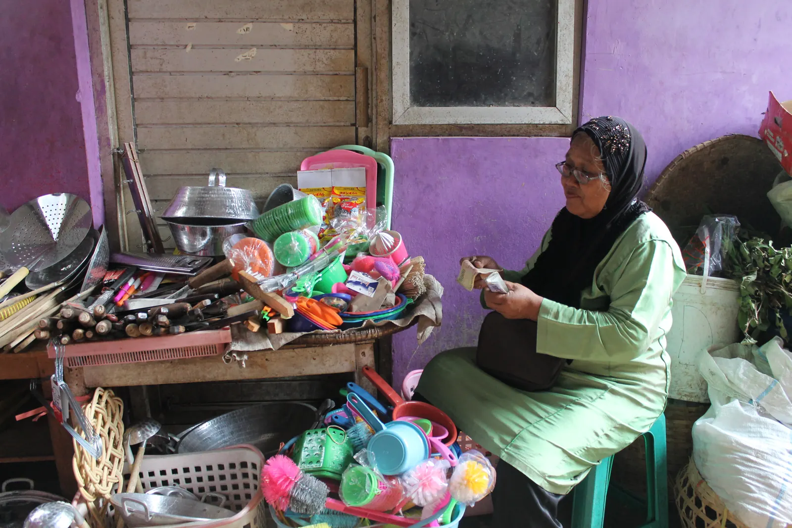 Pedagang perabot rumah tangga di pasar tradisional menghitung uang, contoh wajib pajak PPh final UMKM