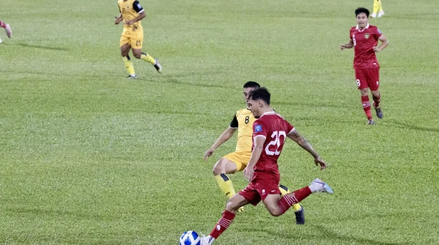 Pemain Timnas Indonesia berjersey merah nomor 20 menendang bola saat melawan Brunei