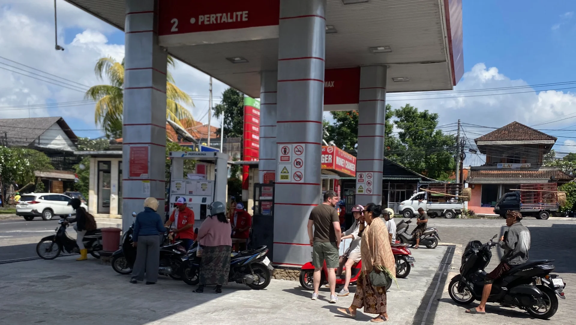 Pengendara sepeda motor mengantre mengisi Pertalite di pompa bernomor 2 SPBU Pertamina Ubud, Bali, dilayani petugas berseragam merah