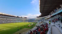 Penonton berbaju merah di tribun Stadion Gelora Bung Tomo Surabaya saat pertandingan sore hari
