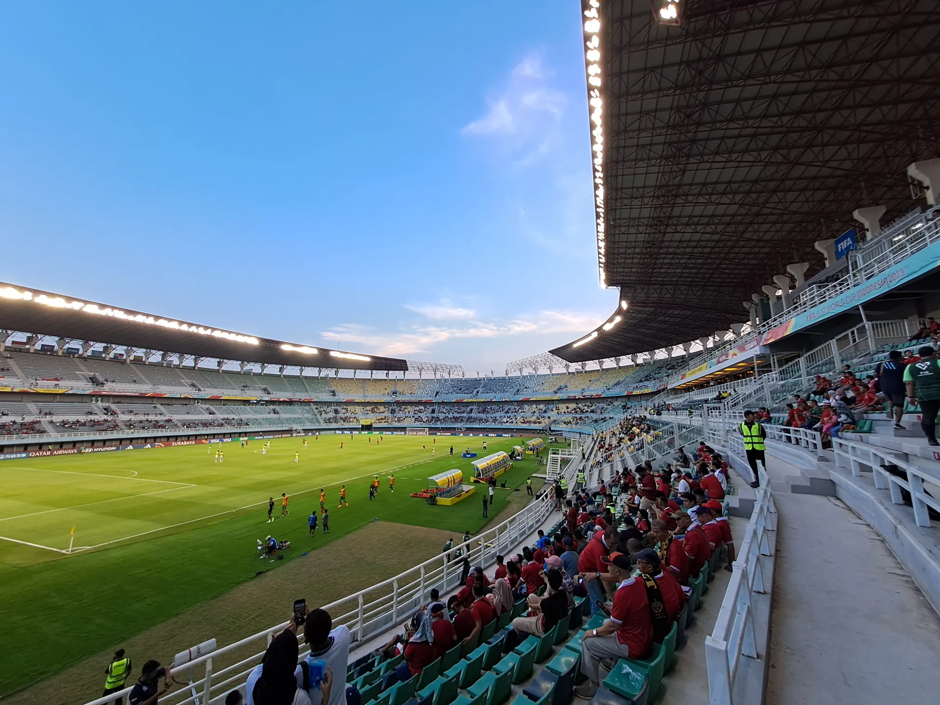 Penonton berbaju merah di tribun Stadion Gelora Bung Tomo Surabaya saat pertandingan sore hari