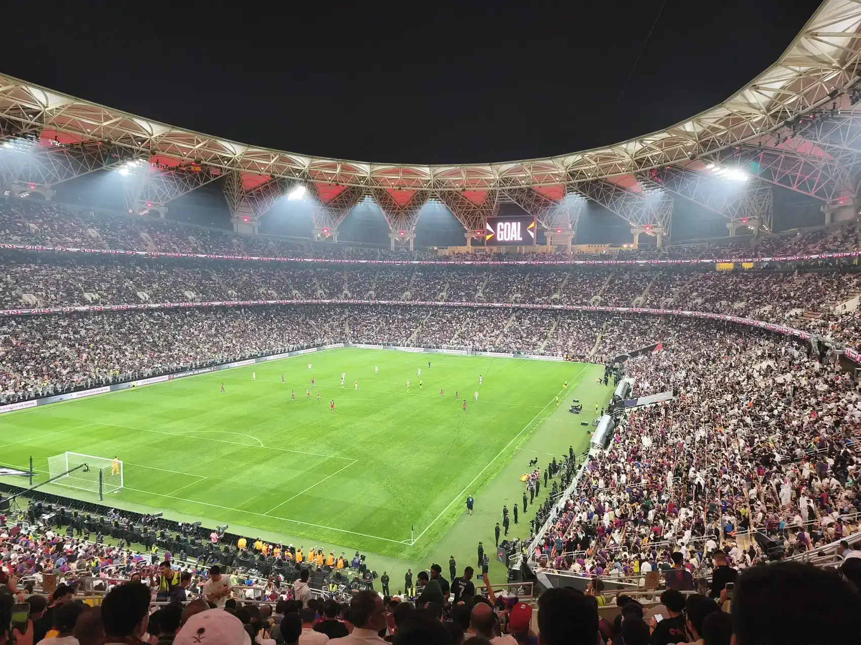 Laga malam di Stadion King Abdullah Sports City Jeddah dengan tribun penuh penonton dan atap rangka baja