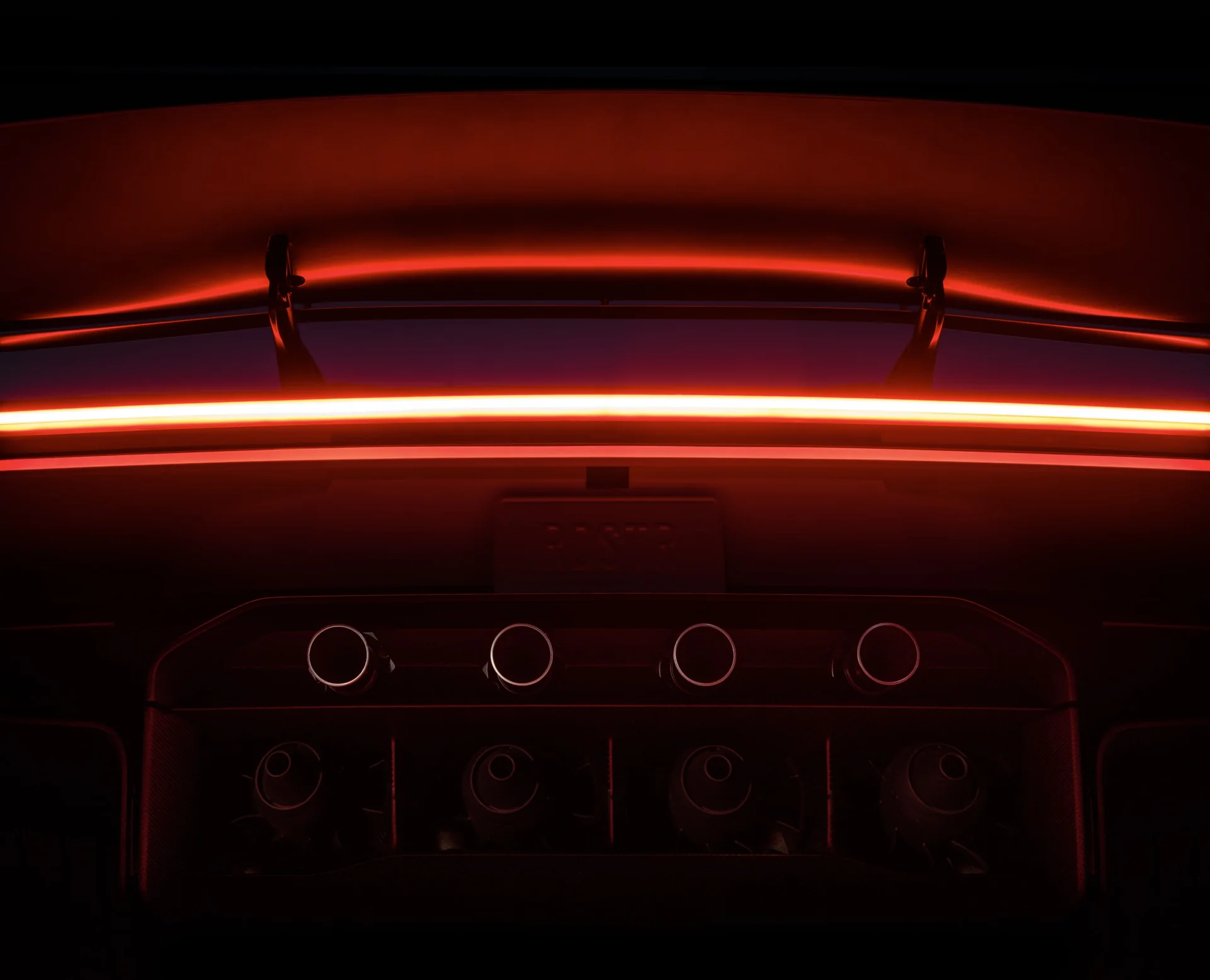 Sayap belakang dan empat nosel thruster Tesla Roadster dalam cahaya merah