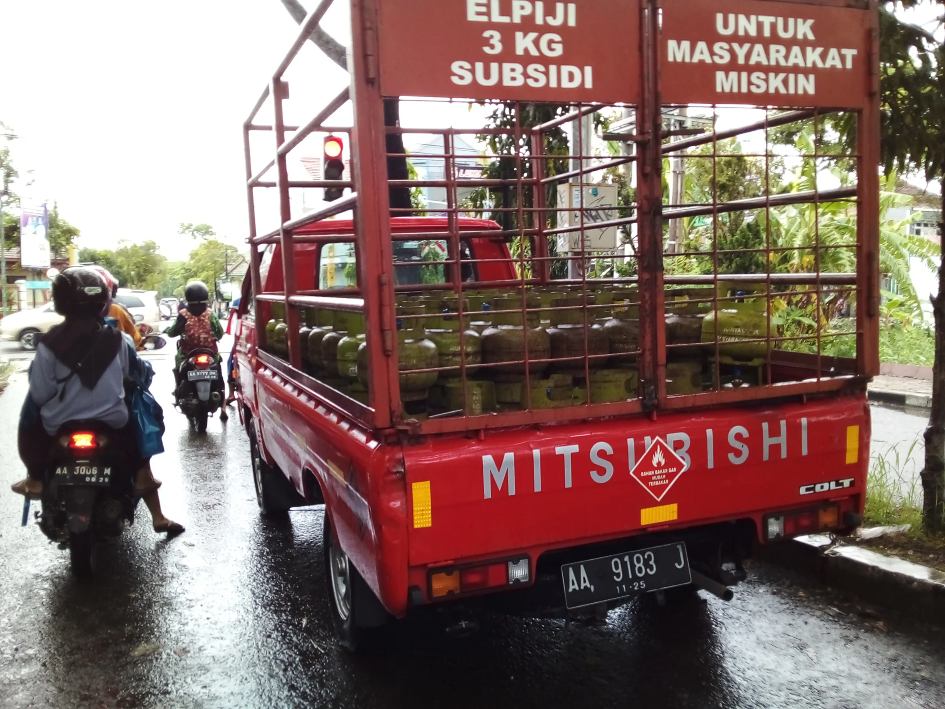 Truk bak merah bertuliskan Elpiji 3 kg subsidi untuk masyarakat miskin mengangkut tabung gas di jalan Kebumen