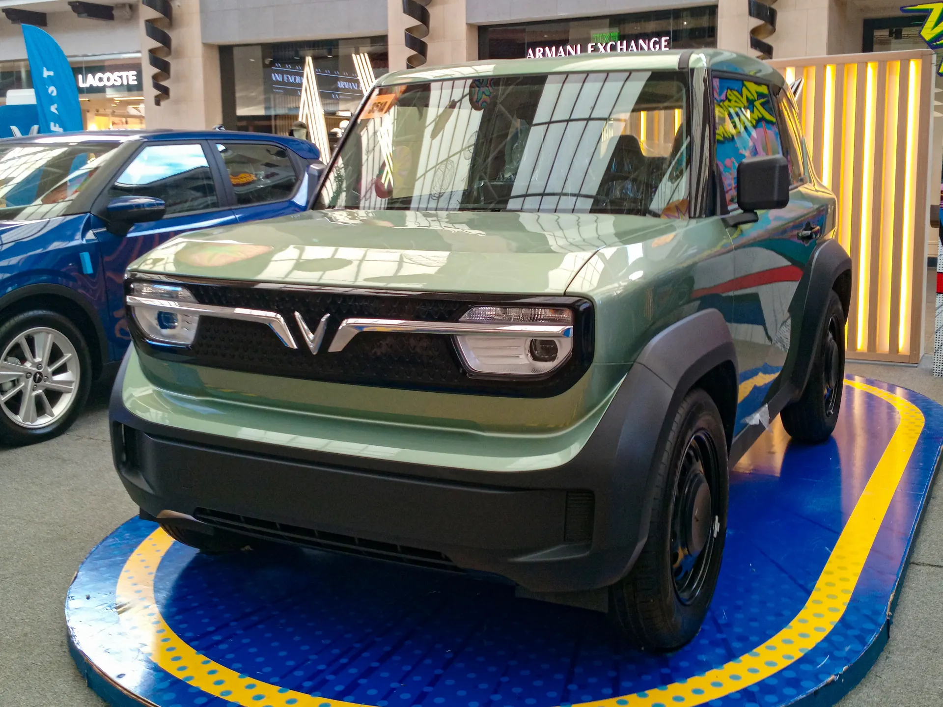 VinFast VF 3 warna hijau dipajang di atas panggung pameran dalam mal